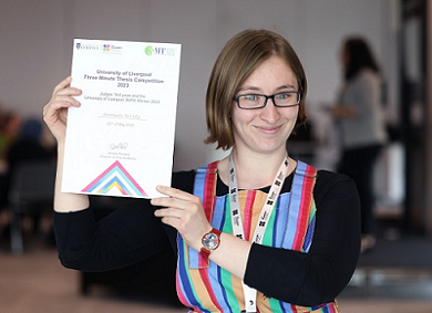 Fionnuala McCully is pictured smiling holding a certificate at the 3MT competition