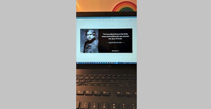 A laptop screen with a cloud file and a rainbow on the wall