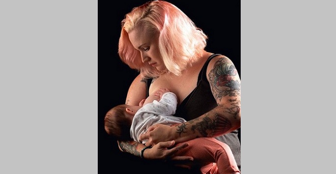A woman with beautiful body art breastfeeding