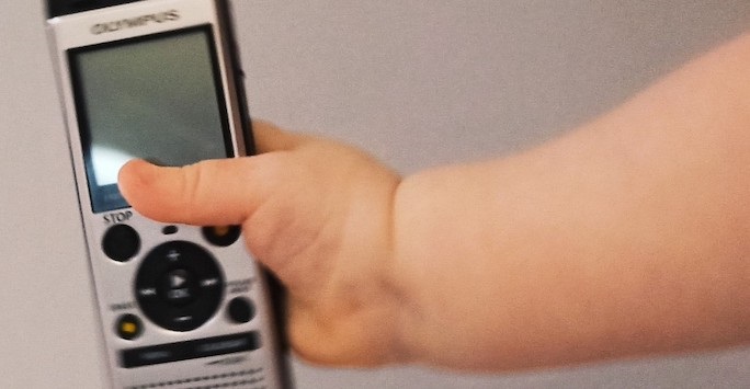 A child's hand holding a presentation clicker