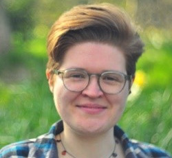 A headshot of a woman with short hair wearing glasses