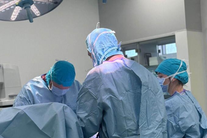 A photo of three veterinary surgeons performing surgery