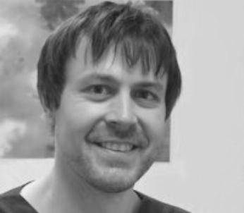 Greyscale image of white male with short dark hair