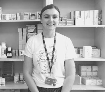 Greyscale image of white female with red hair in a pharmacy setting