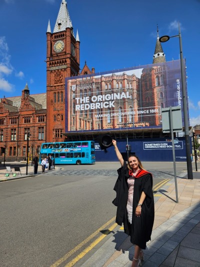 colleague in academic gown stood outside Liverpool University celbrating her graduation