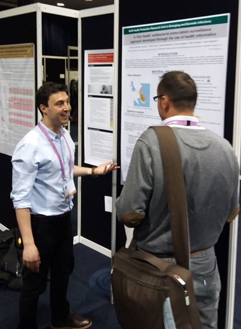 Two males having a discussion in front of a research poster
