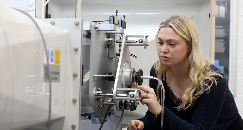 Female mechanical engineering student using wind machine