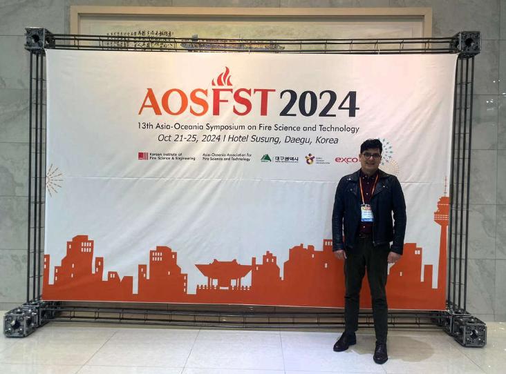 Man standing beside Event poster