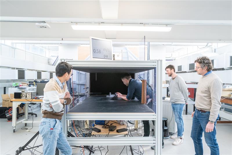 Engineering researchers placing an object in a wind tunnel