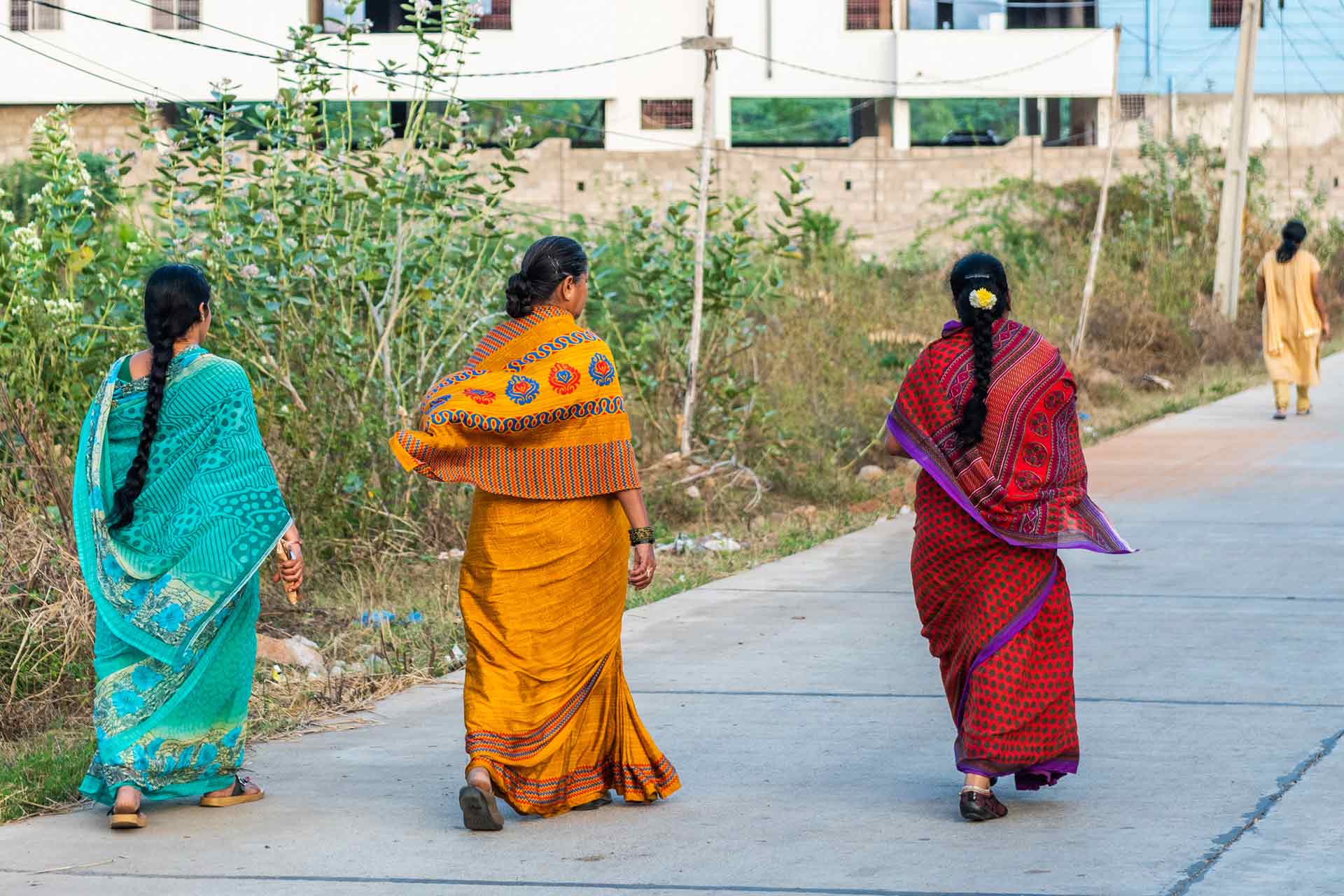 Three woman walking down a street