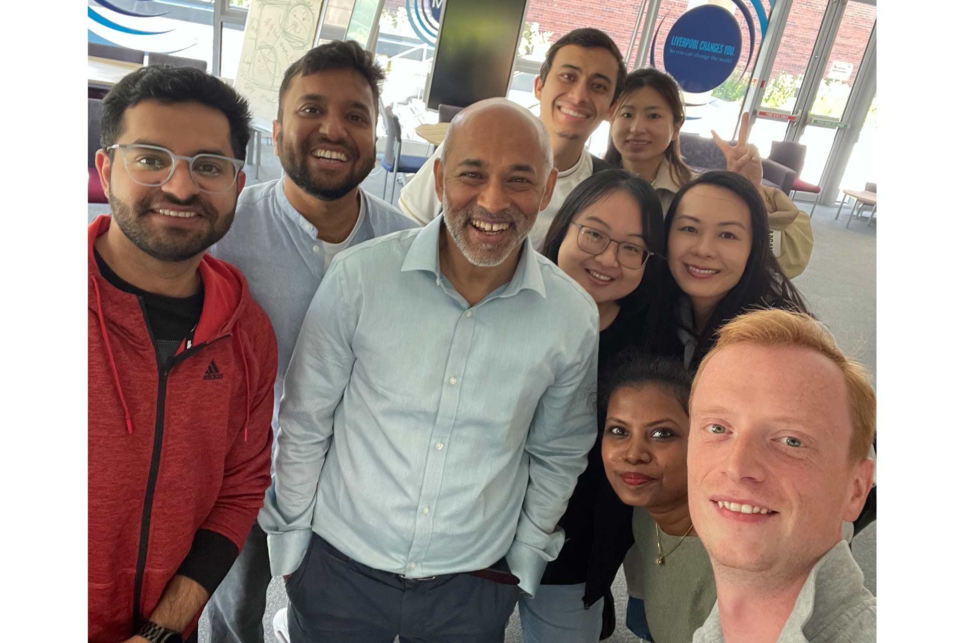 MBA guest speaker Robin Sundaram poses for a picture with MBA students in the Brett Building