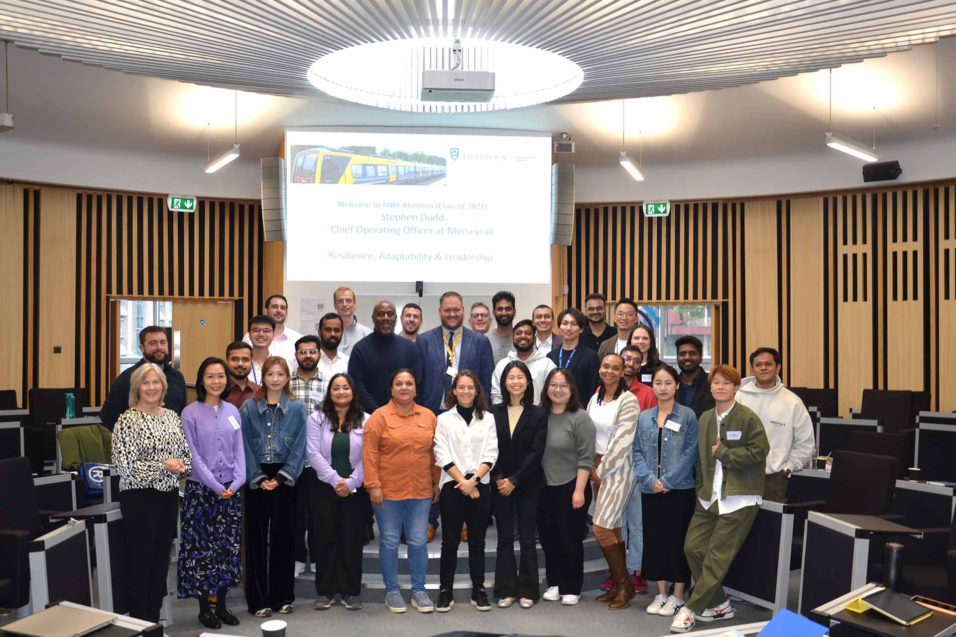 MBA guest speaker Stephen Dodd poses for a picture with MBA students in the drum