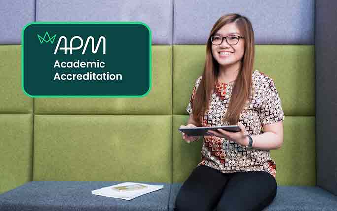 APM academic accreditation badge shown over a photo of a smiling master's student in the Management School atrium