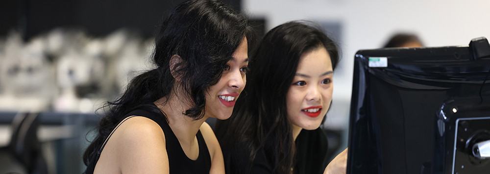 Two postgraduate students work together at a computer
