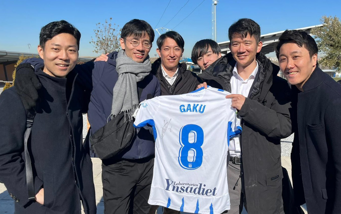 Group of FIMBA students smiling holding signed football shirt