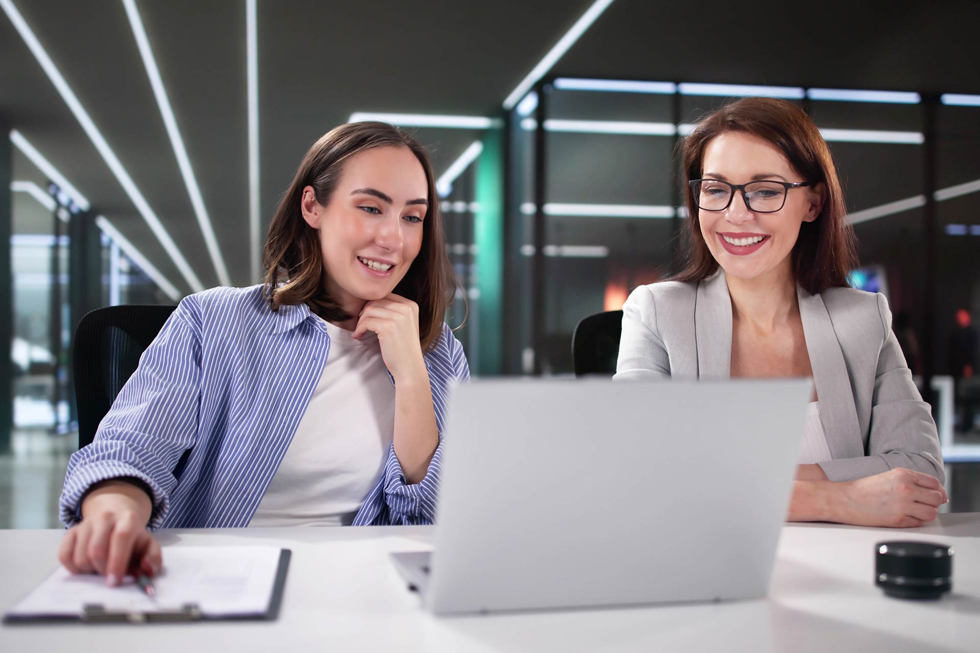 Two women studying online using a laptop