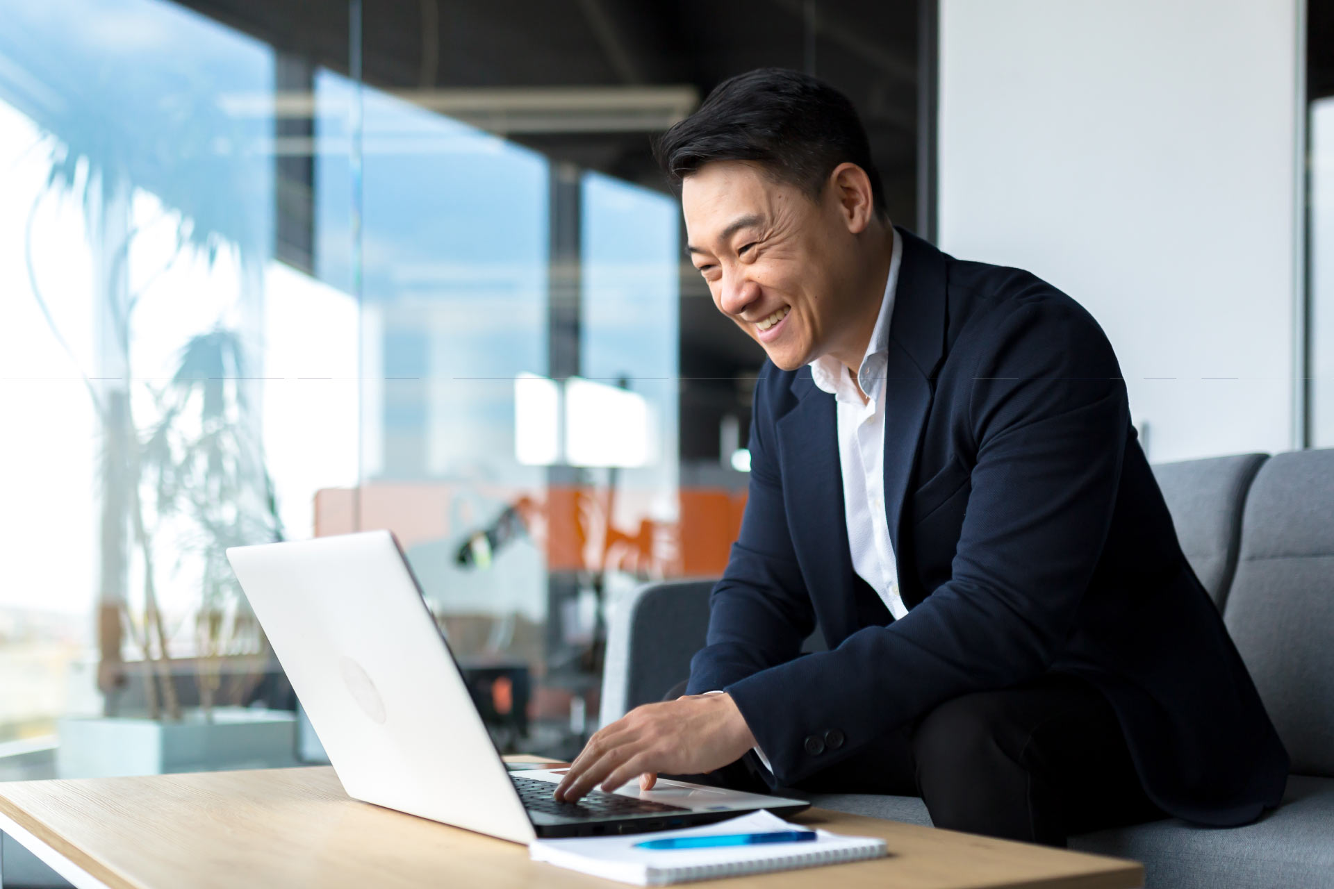 Smiley businessman working on his laptop