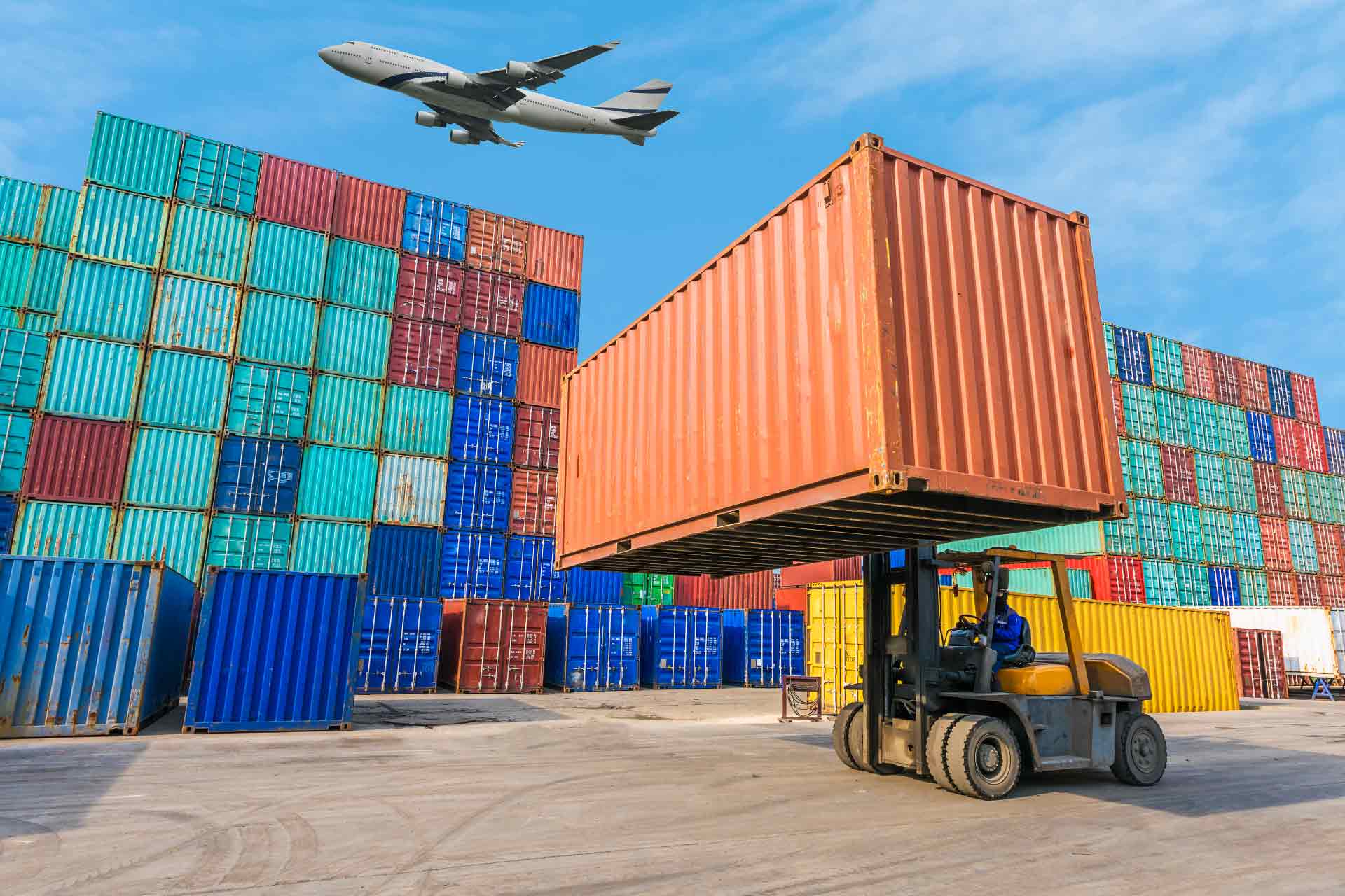 Image of forklift, containers and a plane in the background