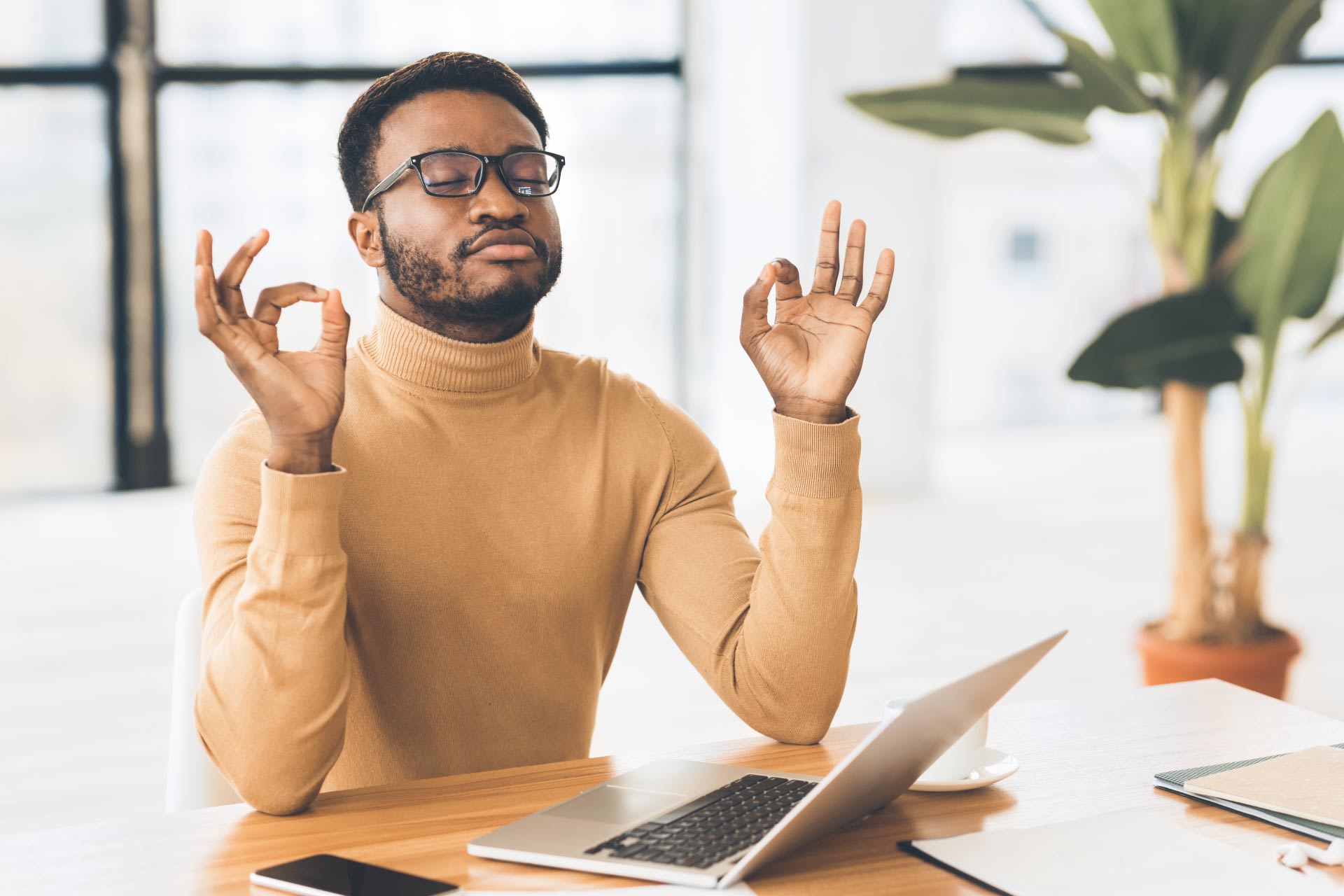 Young male employee meditating in work