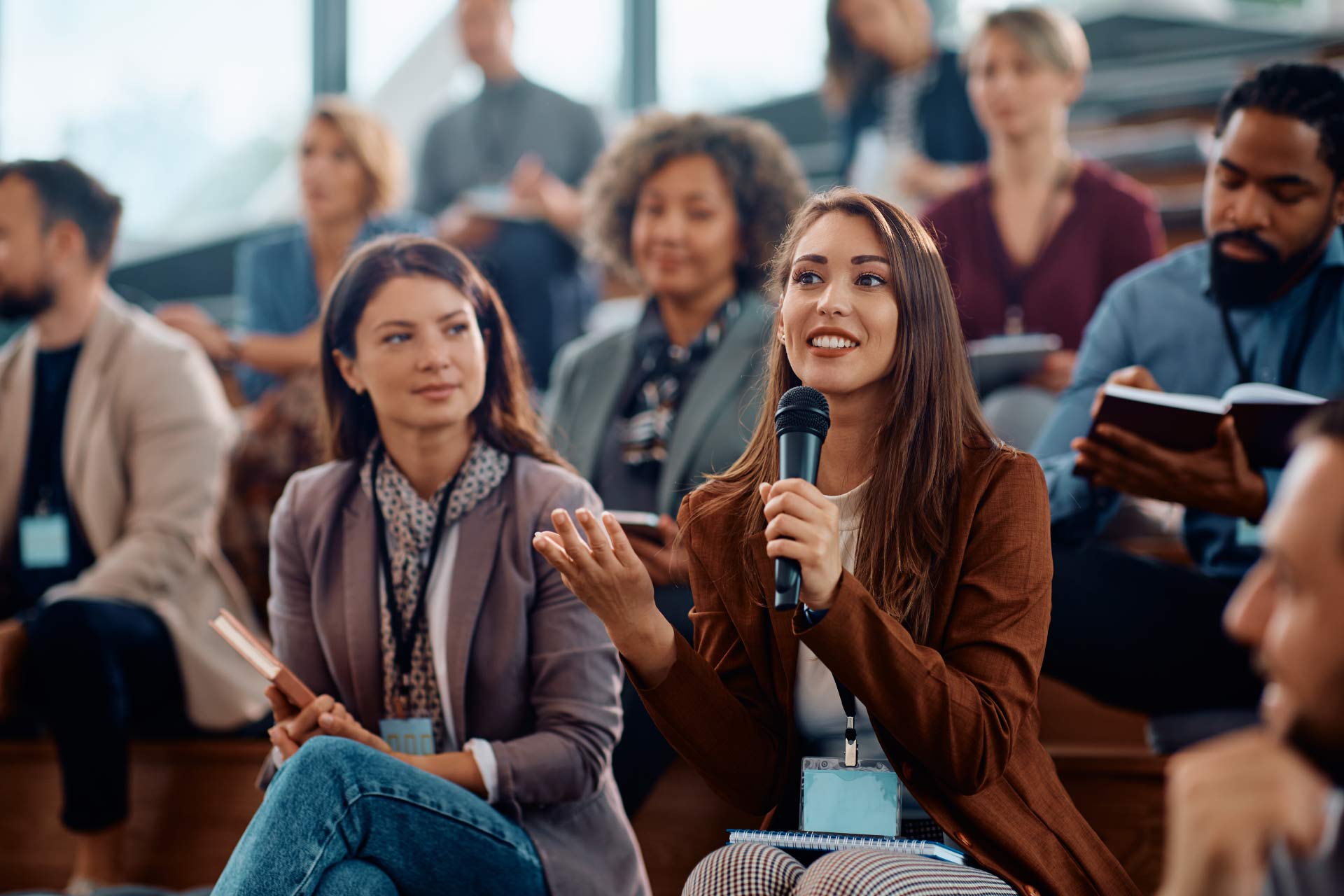 Female guests asks questions during a presentation.