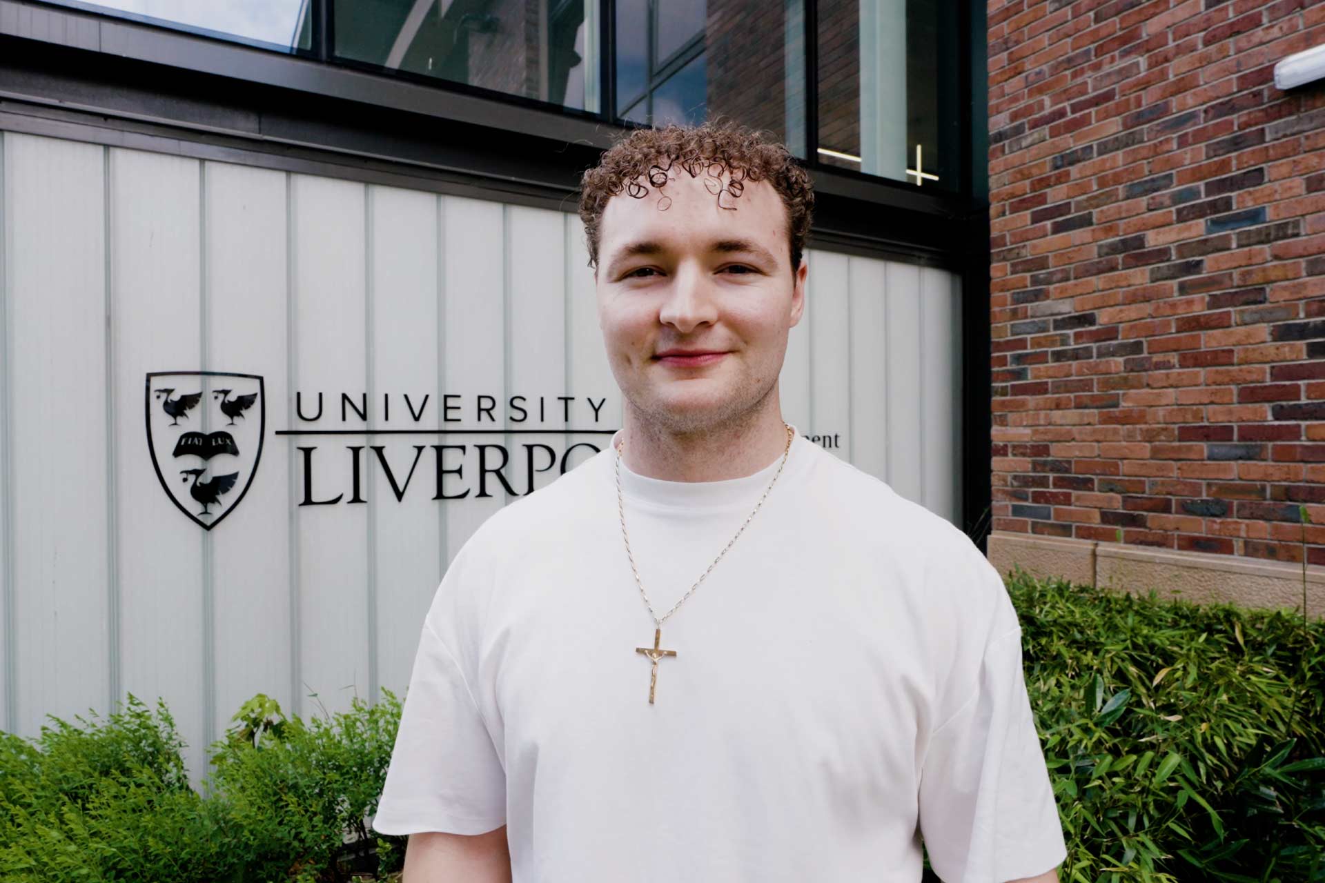 Luke Walsh walking in front of University of Liverpool Management School.