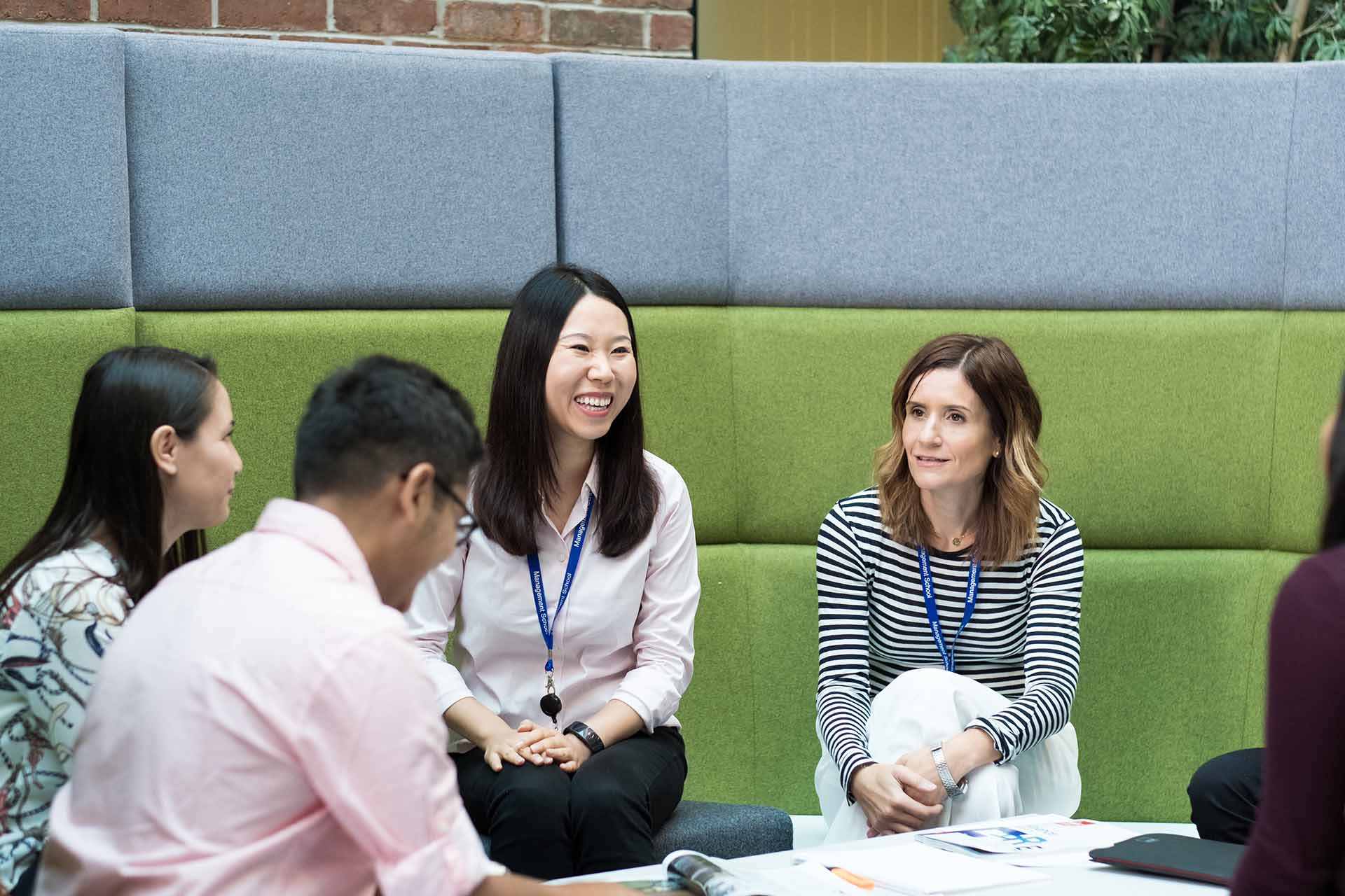 A group of students sitiing in the atrium