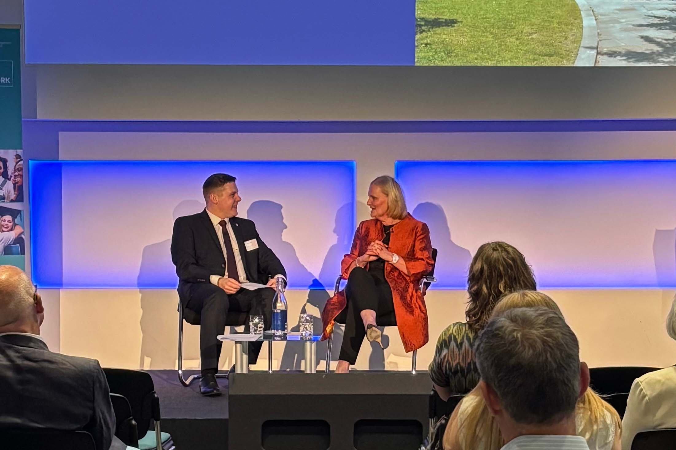Two leaders sitting on the stage discussing at an event