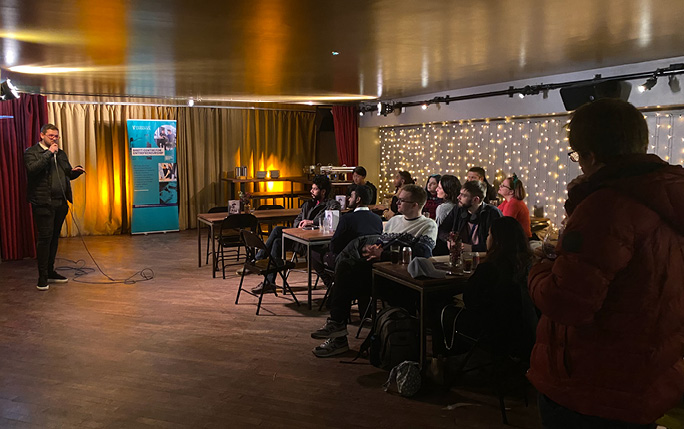Man stood up presenting to group of attendees
