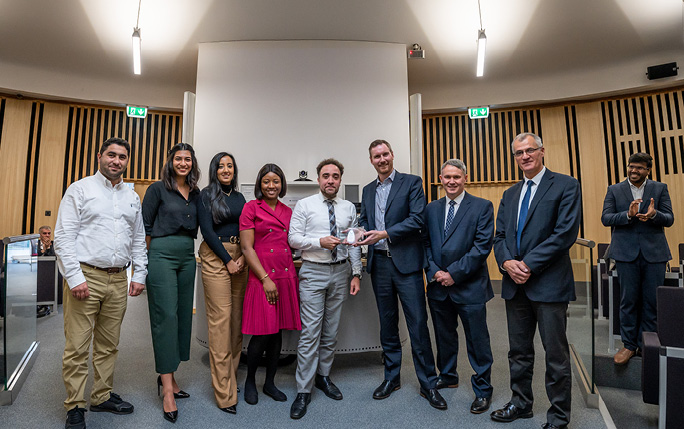 MBA students posing with trophy after winning competition