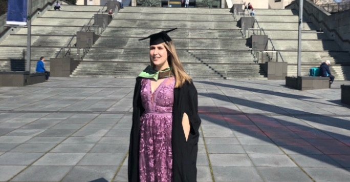 Janie Bamforth outside the Metropolitan Cathedral in graduation cap and gown