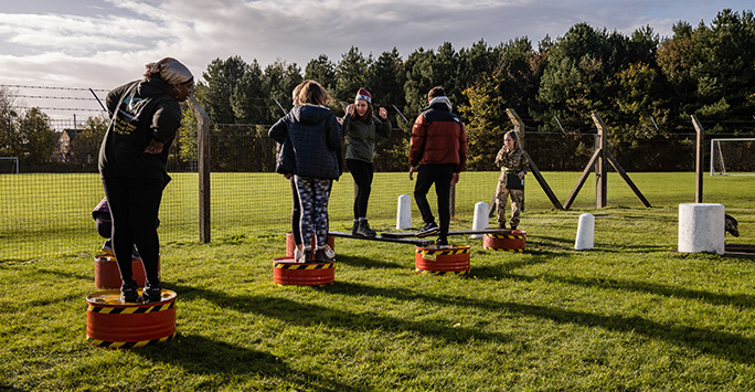 Students stood in a formation line on upturned oil barrels