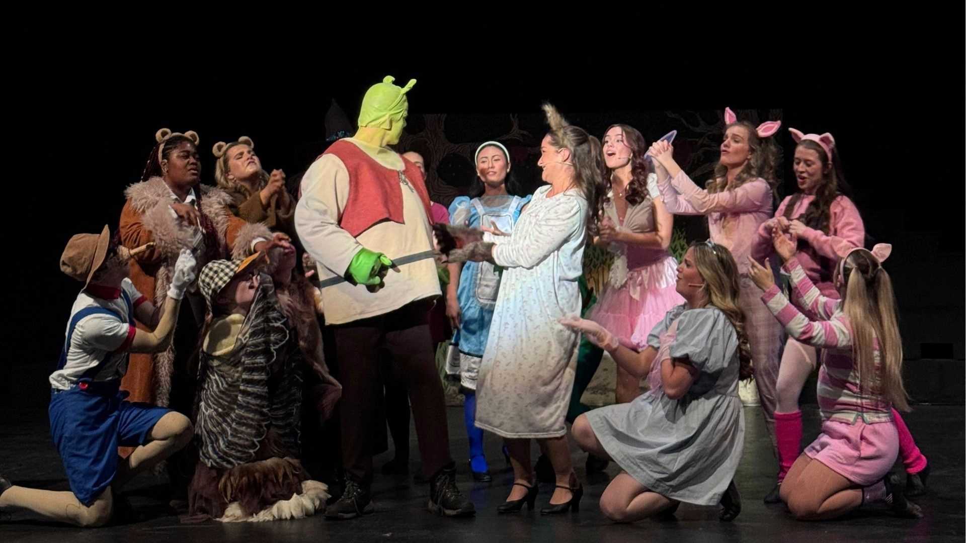 Shrek surrounded by a variety of fairy tale characters