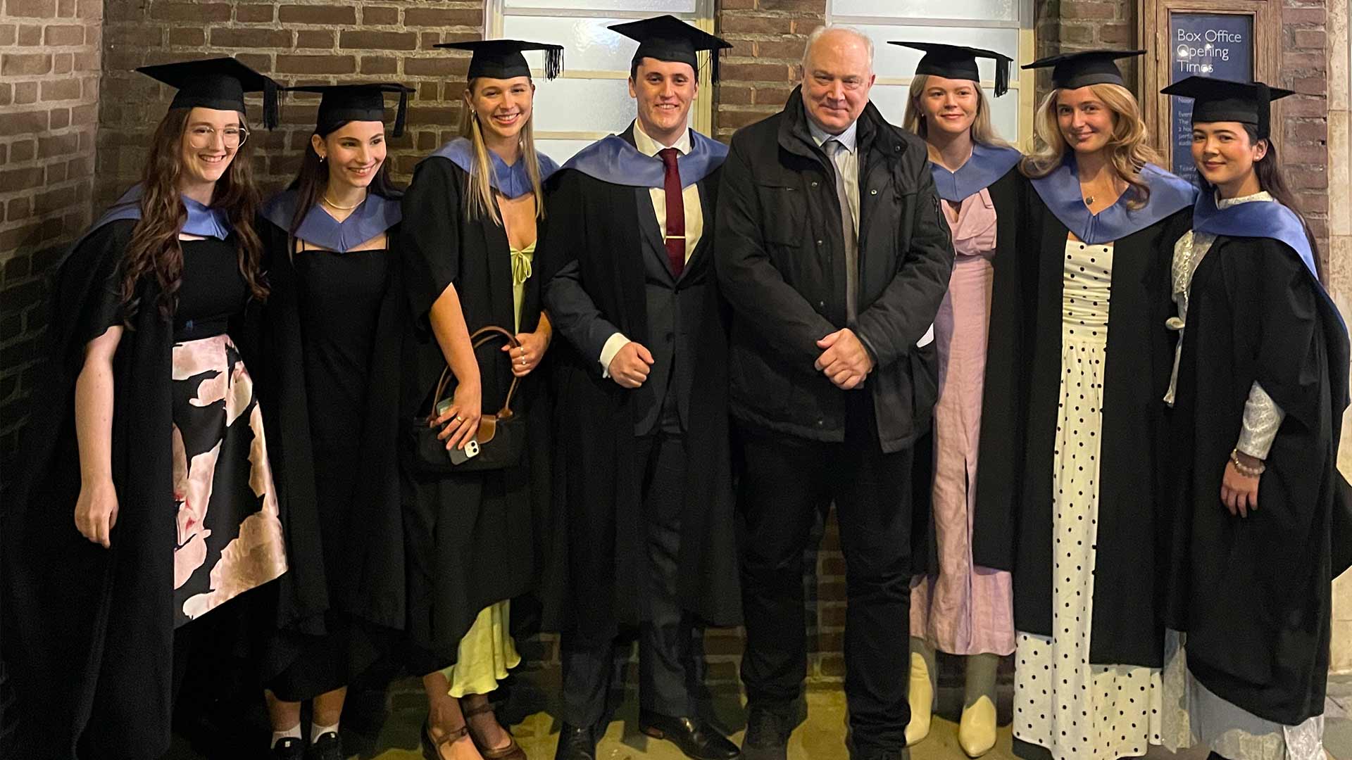 graduates pose with educator