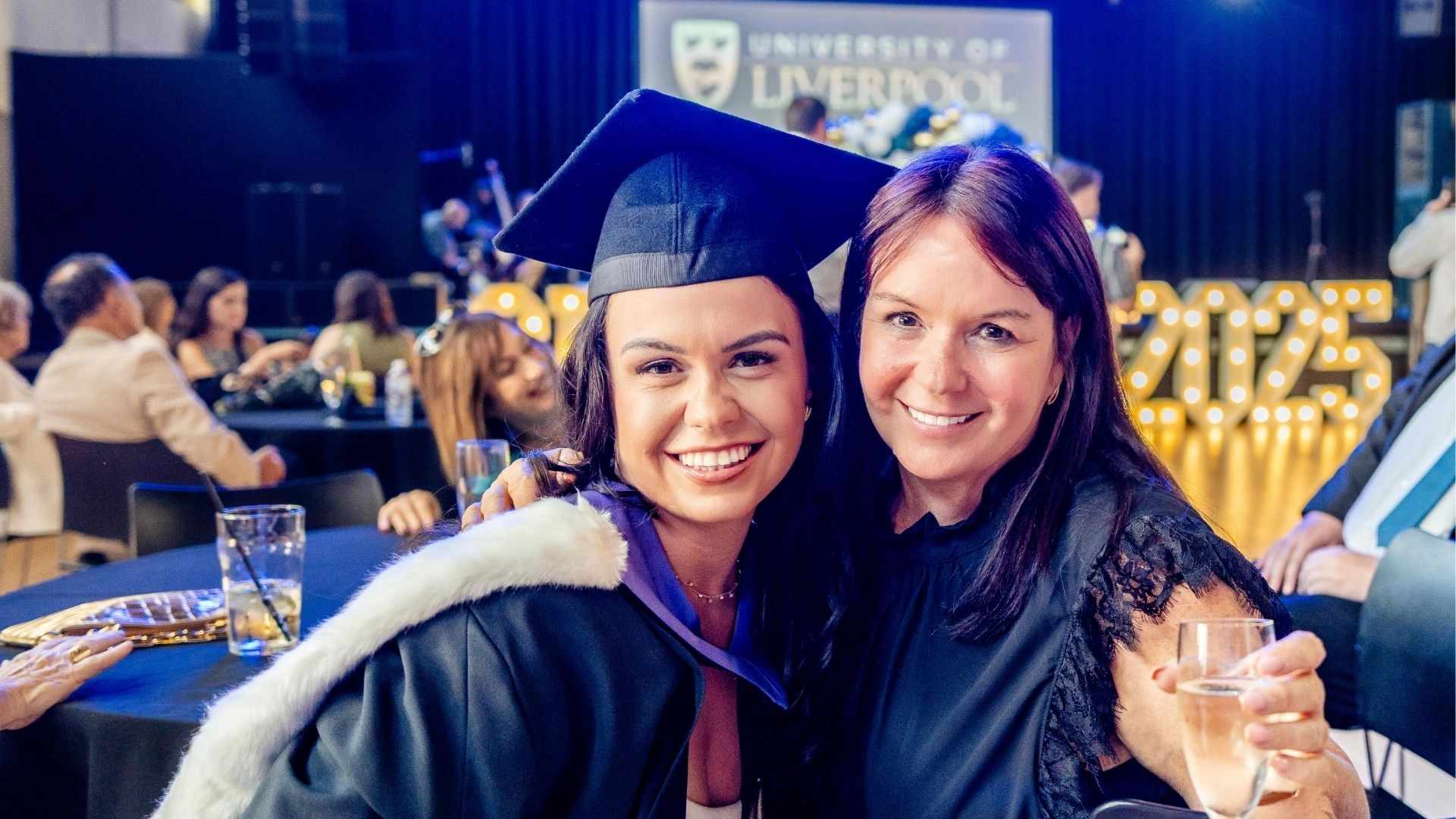 smiling graduate and her guest celebrating inside the reception venue