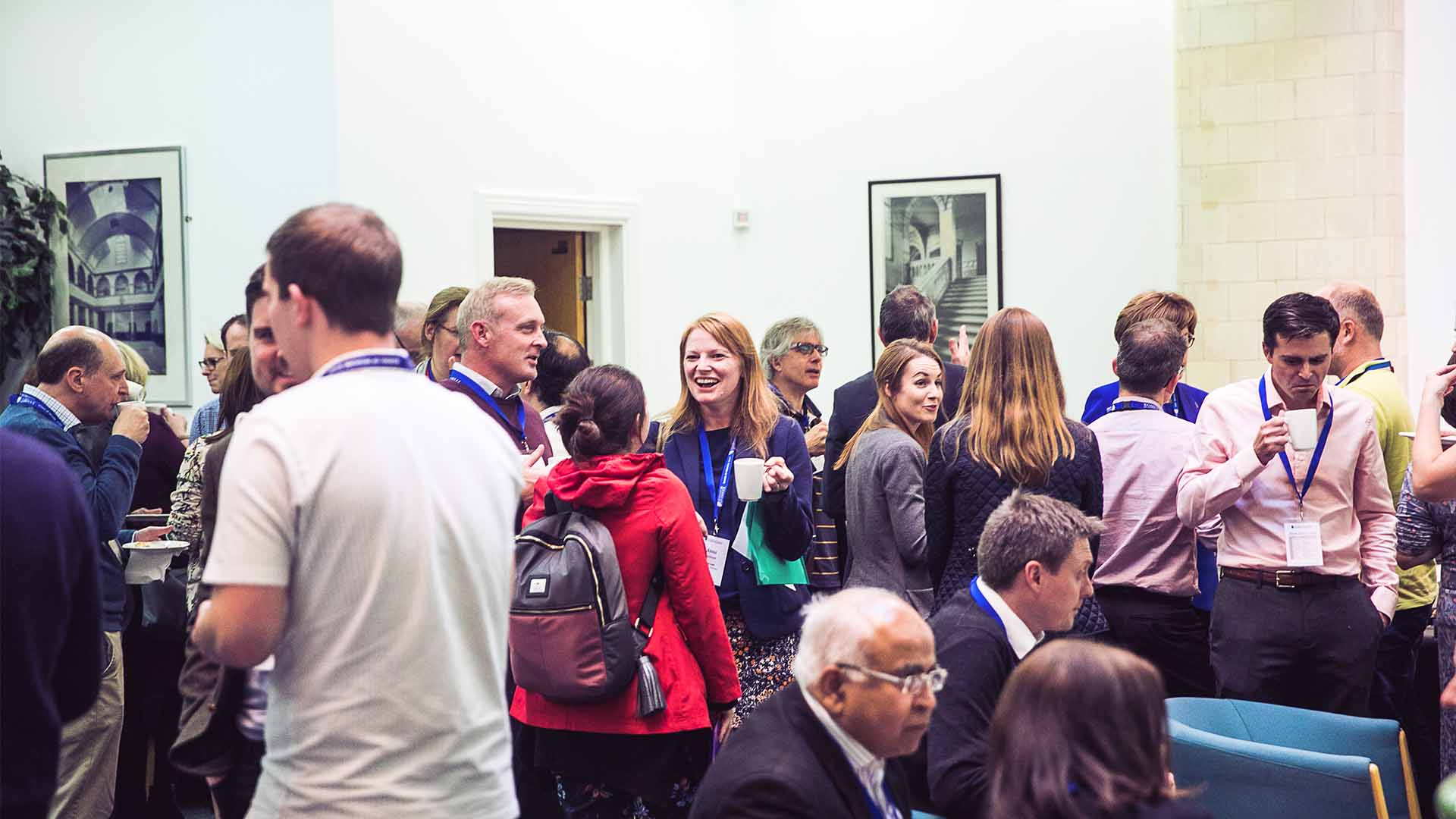 A group of GPs conversing in a large conference space