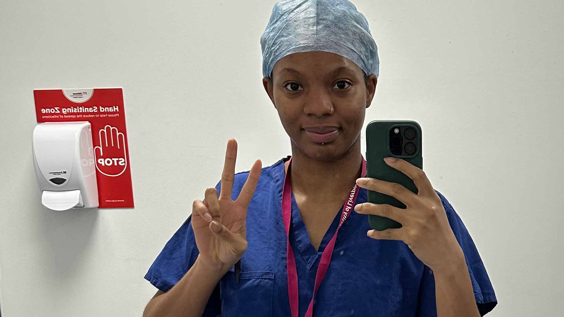 student doctor in blue scrubs with ACE lanyard