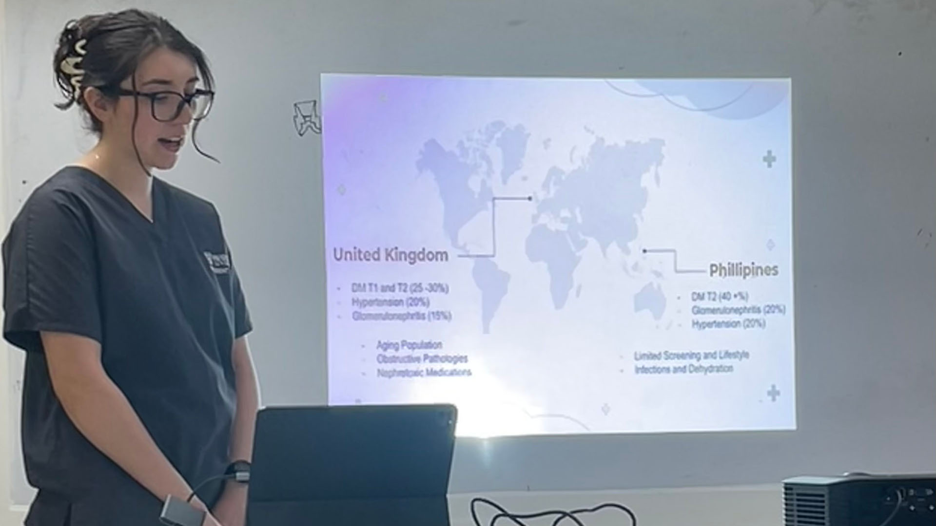 student in grey scrubs gives a presentation on their elective experience in the Phillippines
