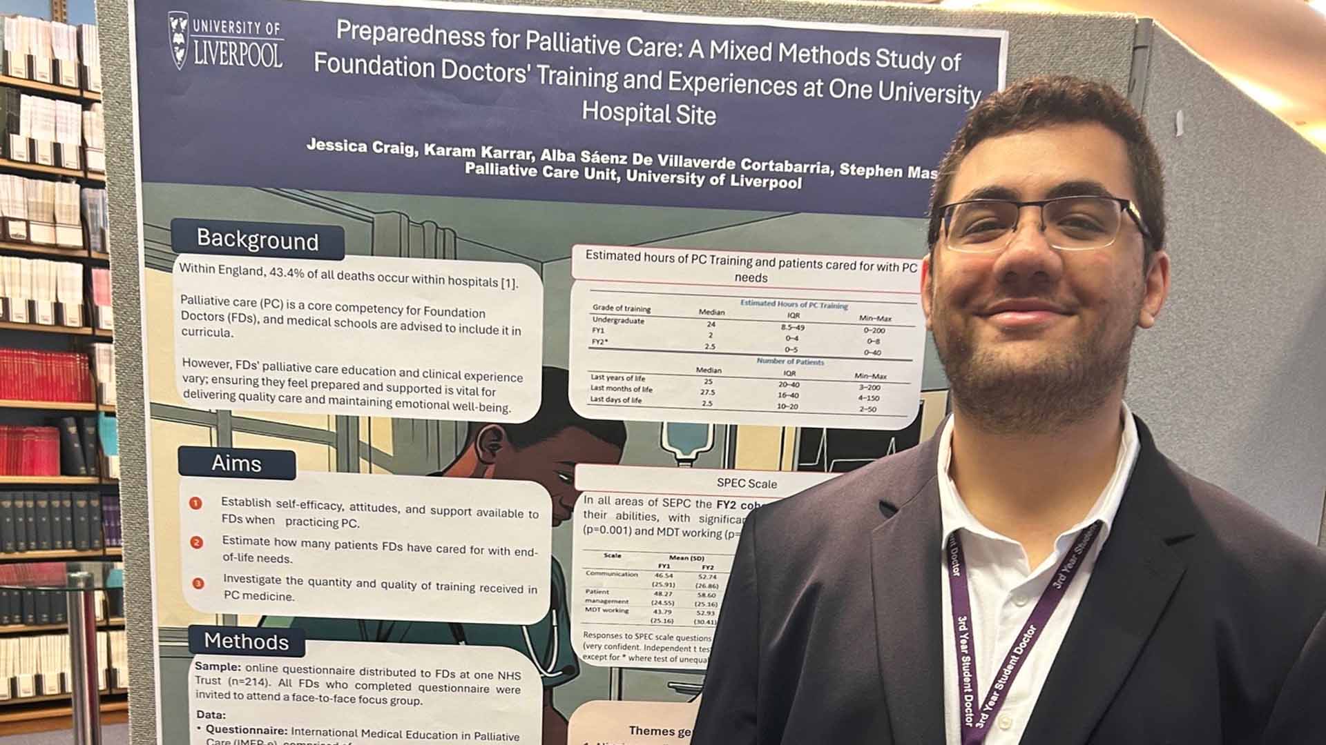 Student in suit and lanyard in front of a research poster