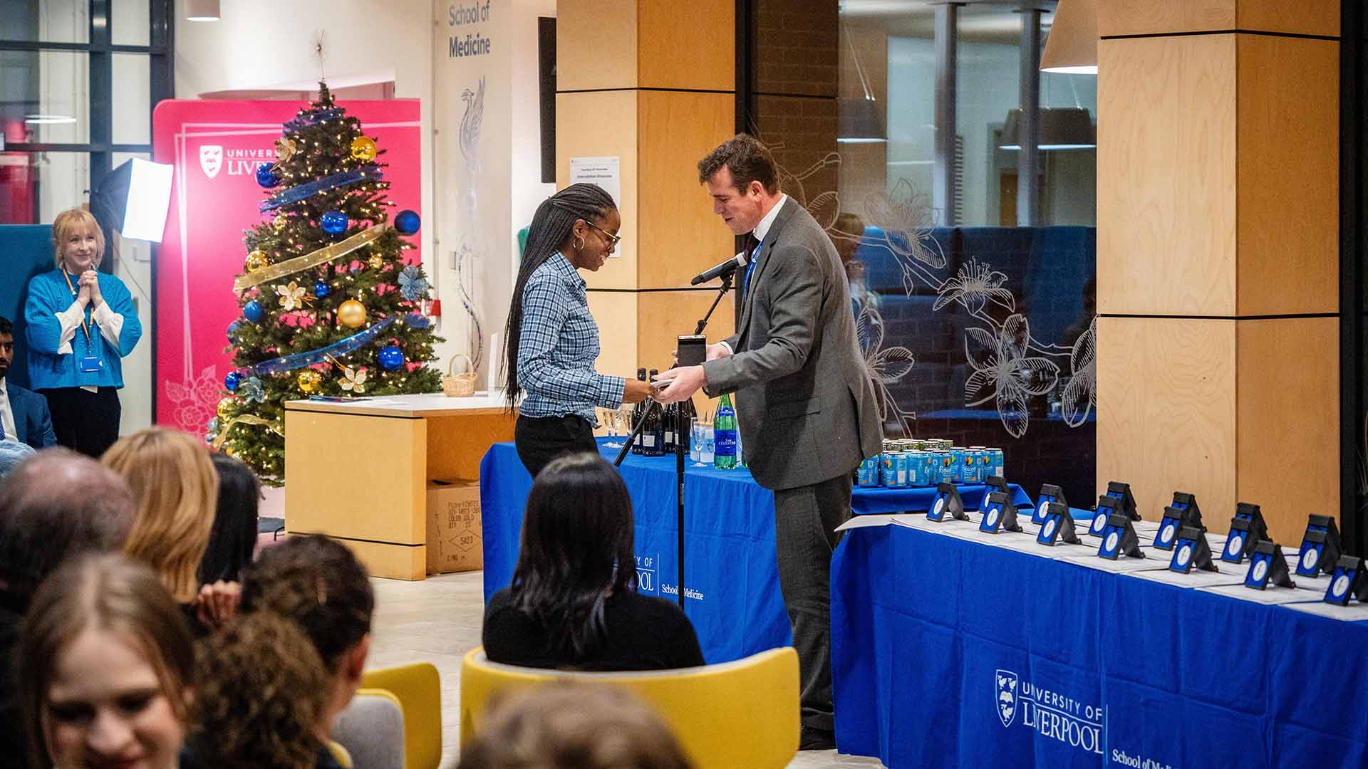 a prize winner is awarded their prize by the Dean