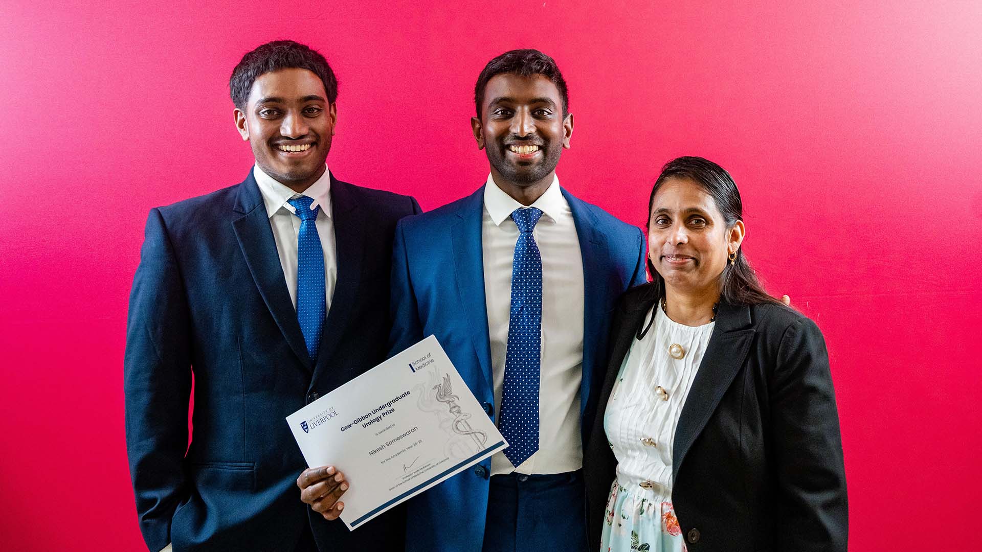 prize winner poses with family members holding award certificate