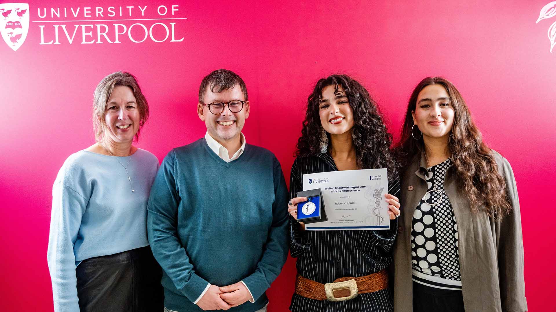 prize judge poses for a photo with winner and family members