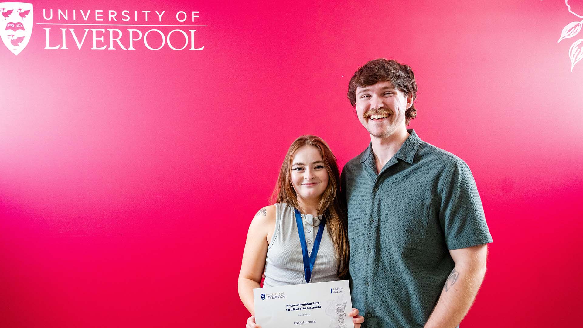 prize winner poses with certificate and medal with her partner