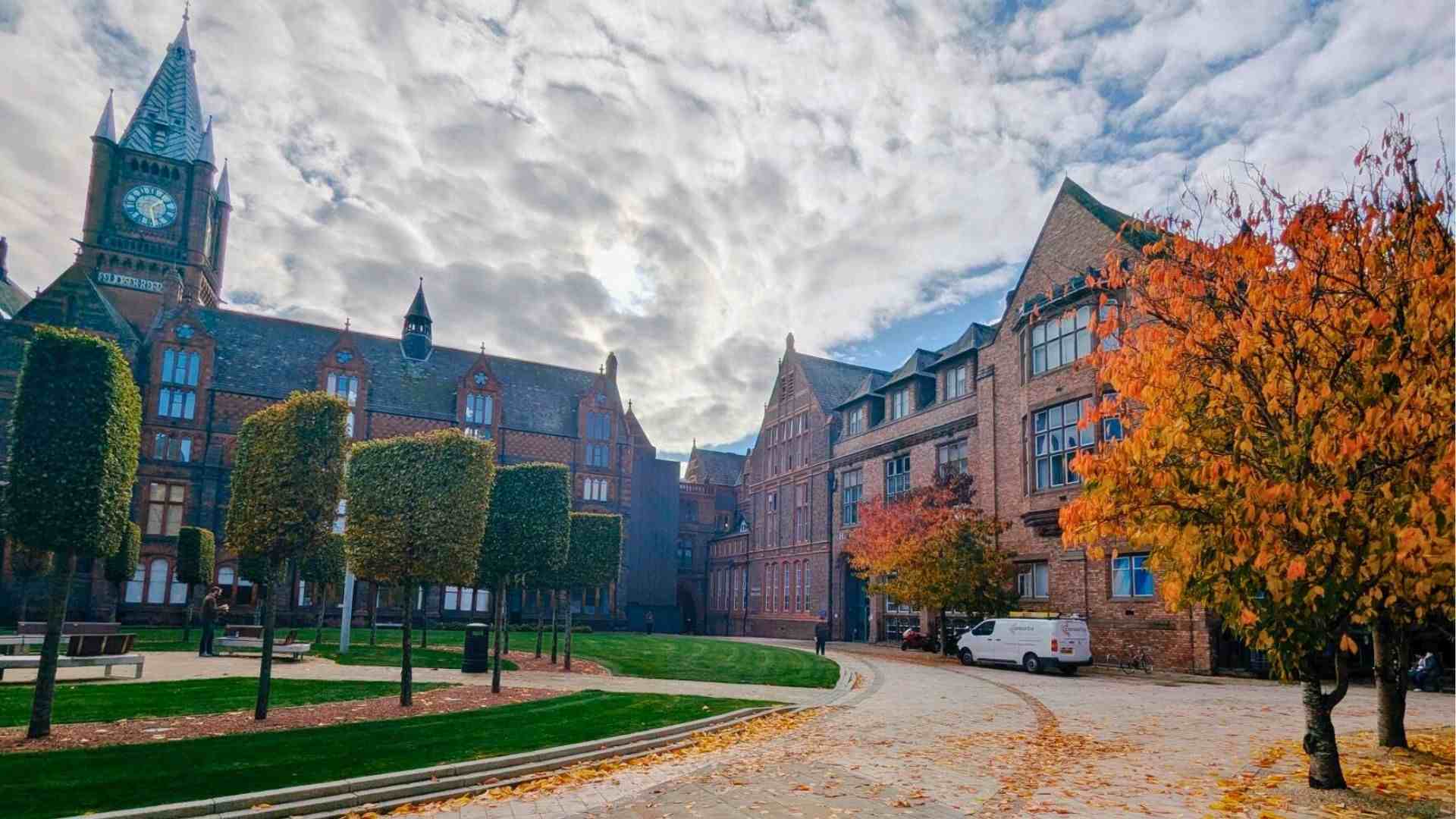 Liverpool’s Victoria Building courtyard, with golden-orange trees and the clock tower