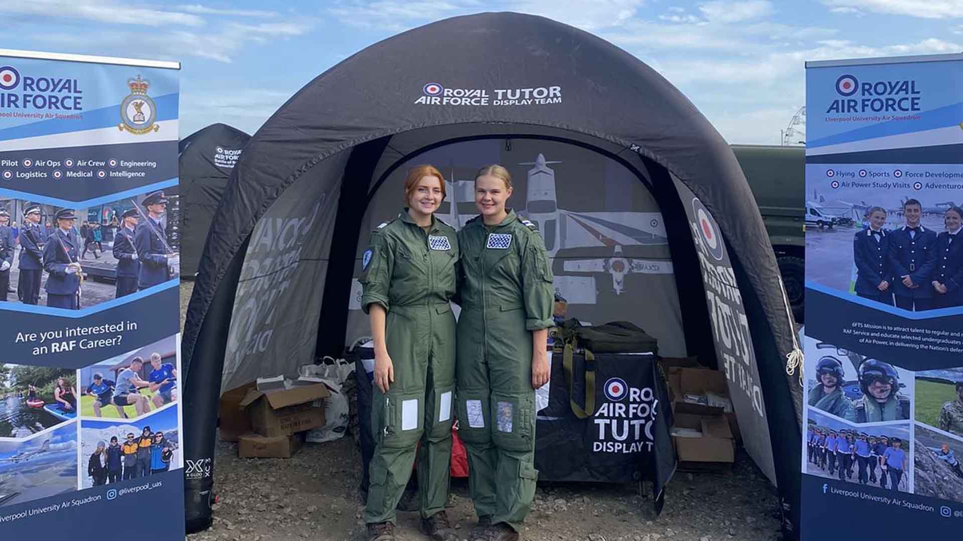 two medical cadets pose in uniform in front of a tent branded RAF