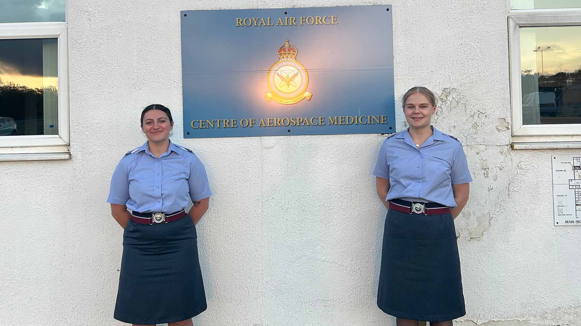 Two medical cadets in uniform in front of an RAF sign