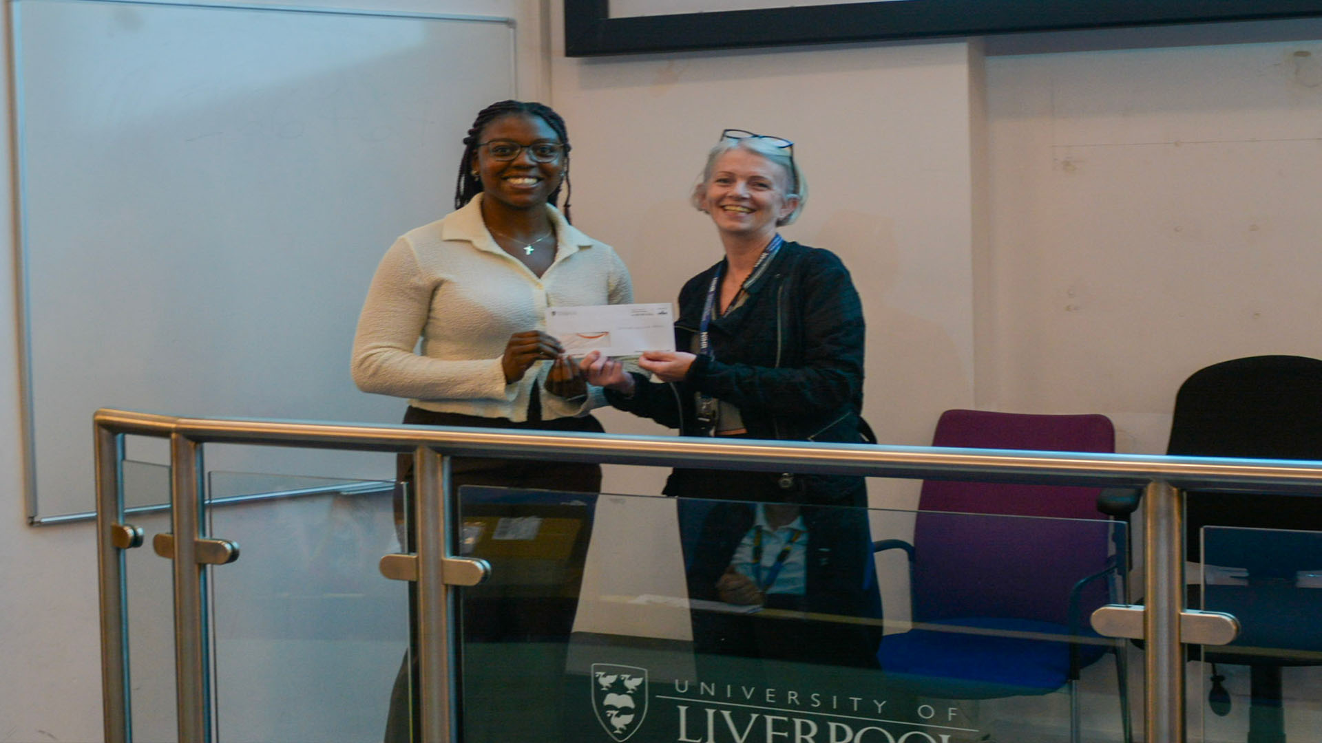 Student Doctor Emmanuella is awarded for her winning presentation by Professor Kenny