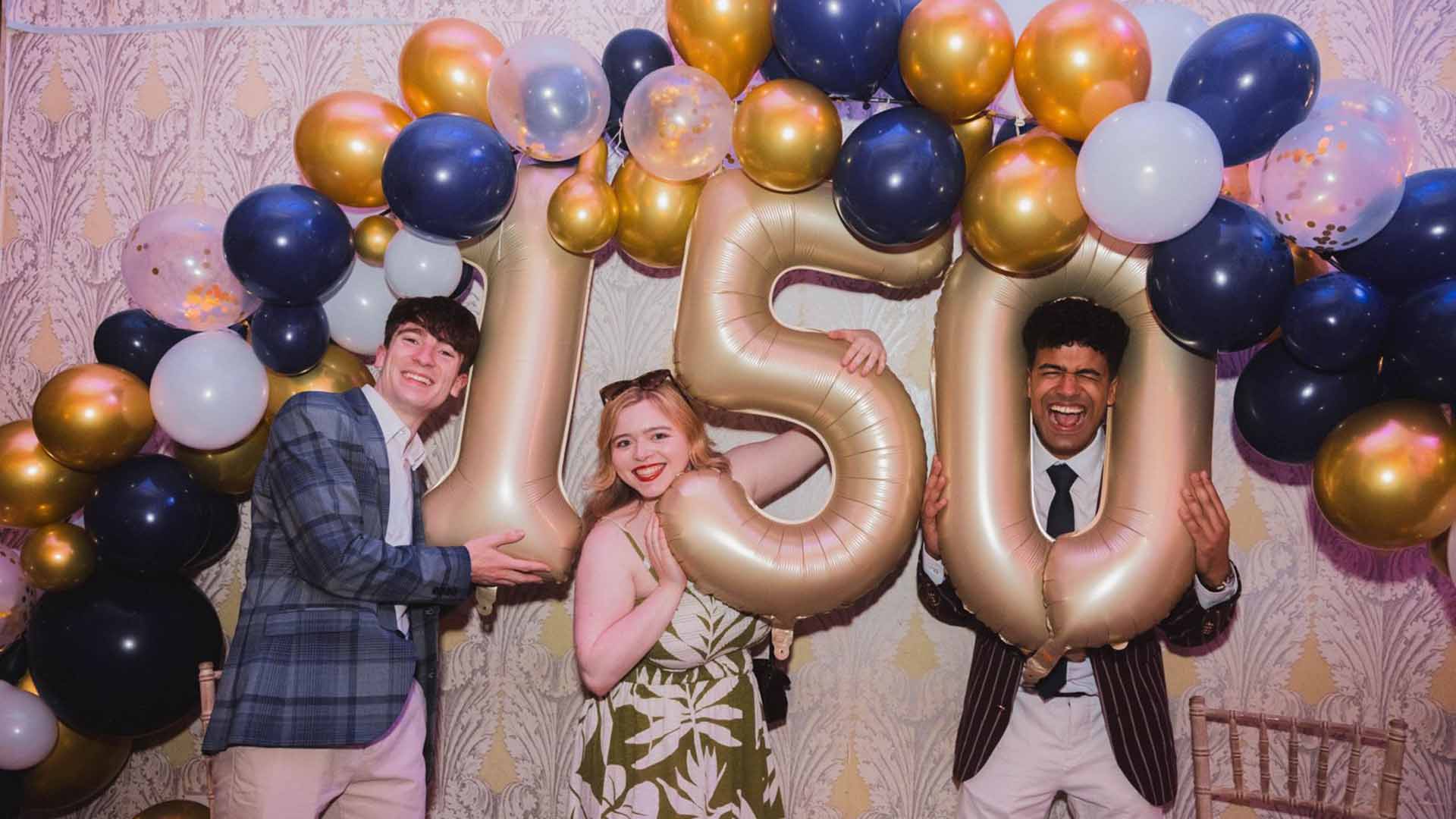Students pose with number balloons 1 5 0