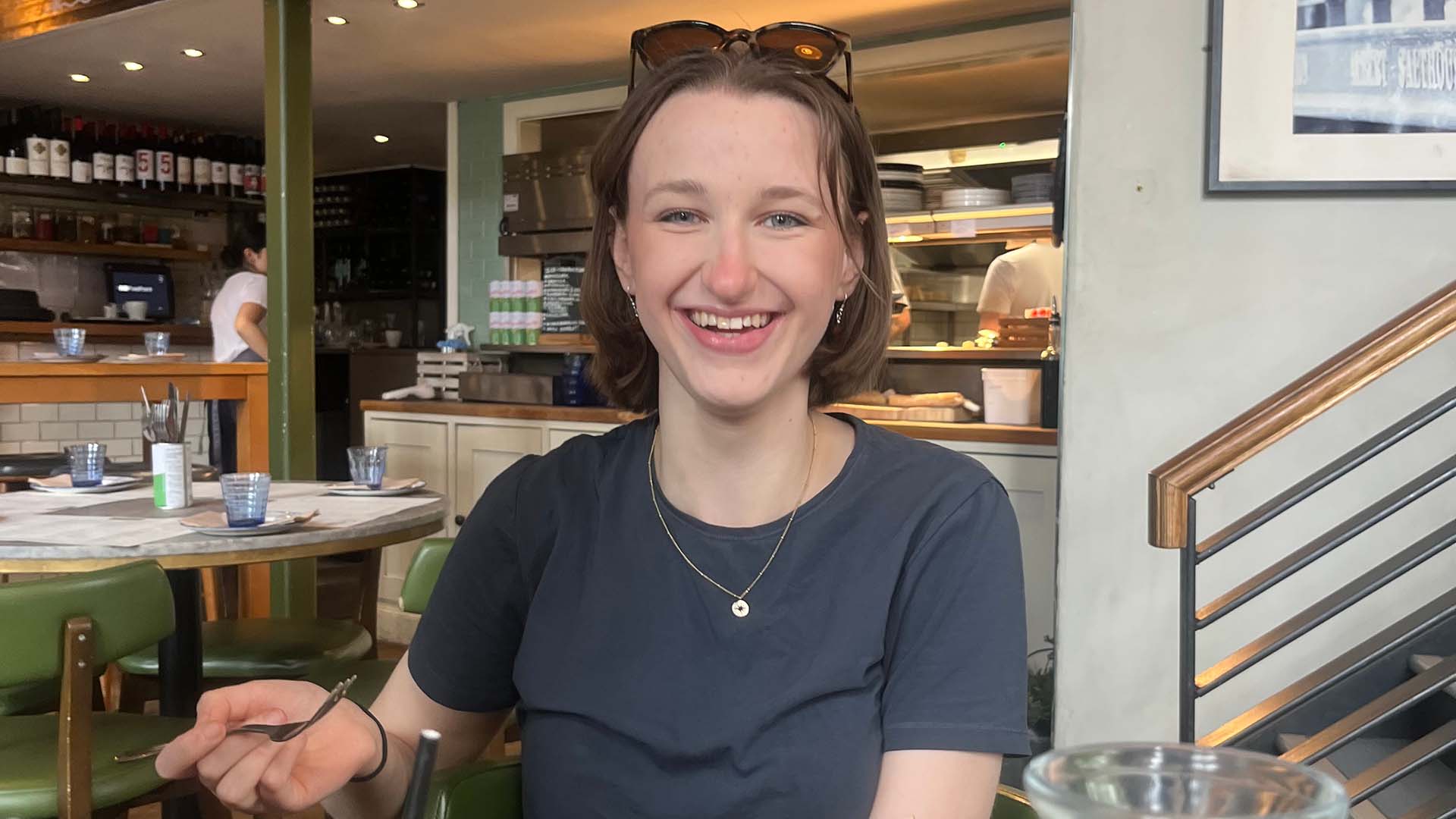 a woman smiling at a restaurant table