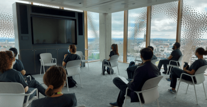 students debrief in a meeting room with beautiful views