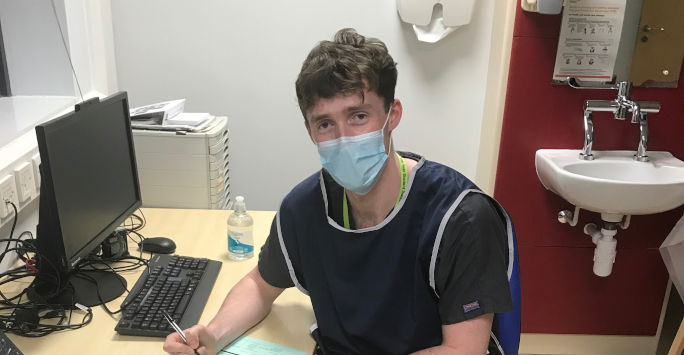 student sitting at desk wearing a mask